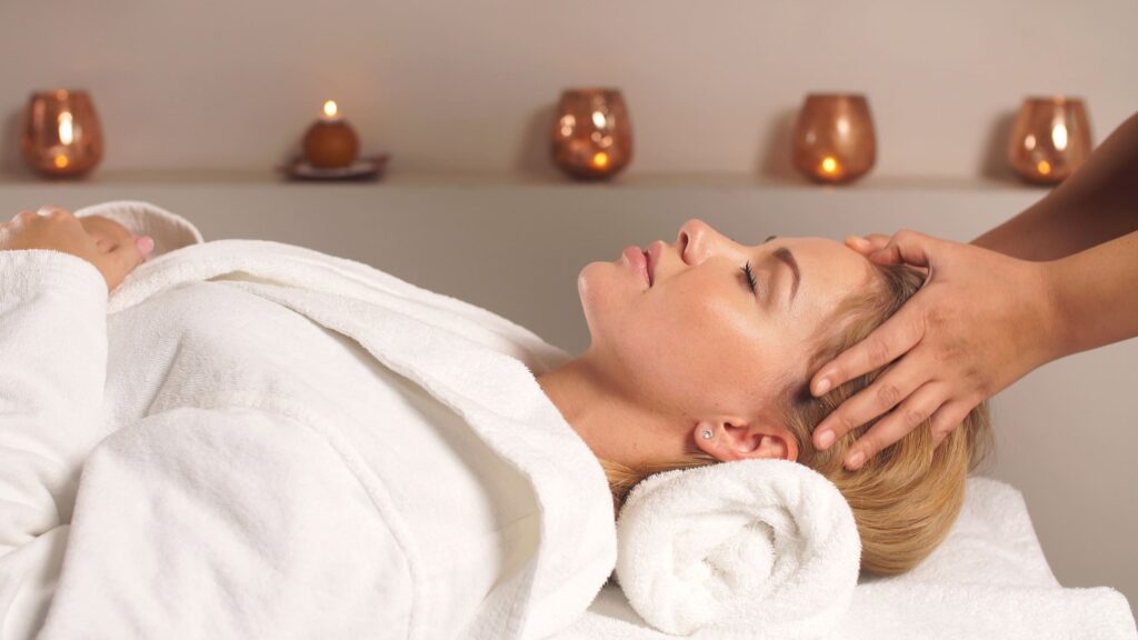 Woman in a white robe enjoying a head massage